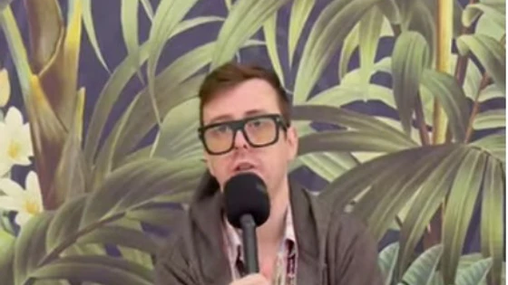 Jon Craig, the new Student President at Glasgow Kelvin College, speaking into a microphone while seated on a green couch in front of a botanical mural. Jon Craig, the new Student President at Glasgow Kelvin College, speaking into a microphone while seated on a green couch in front of a botanical mural.